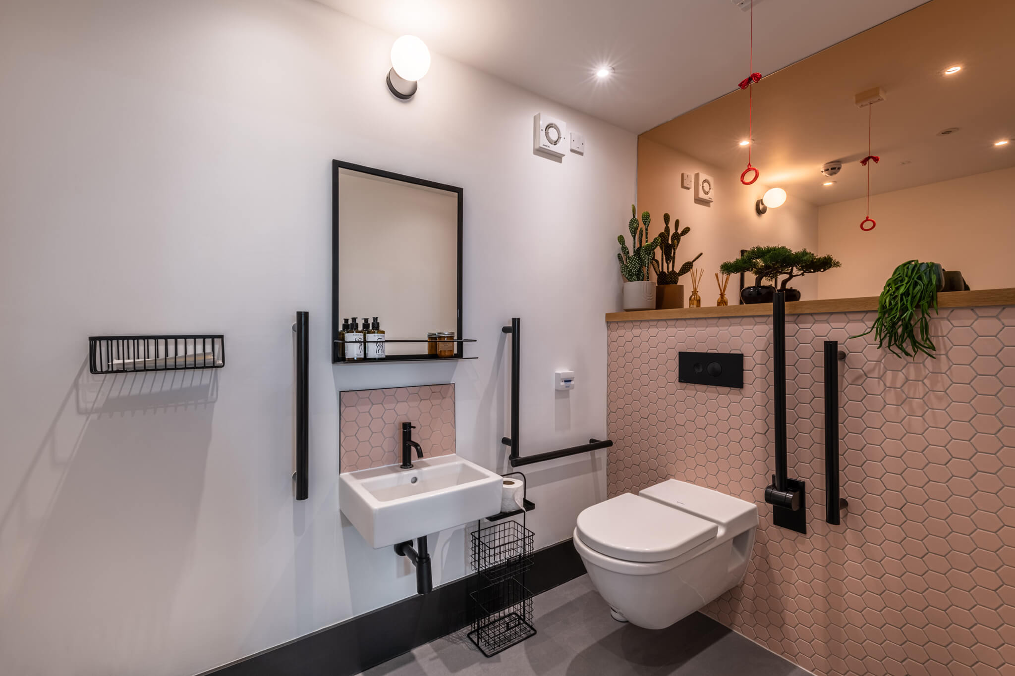 Modern bathroom with a large mirror behind the toilet and a small mirror opposite the sink