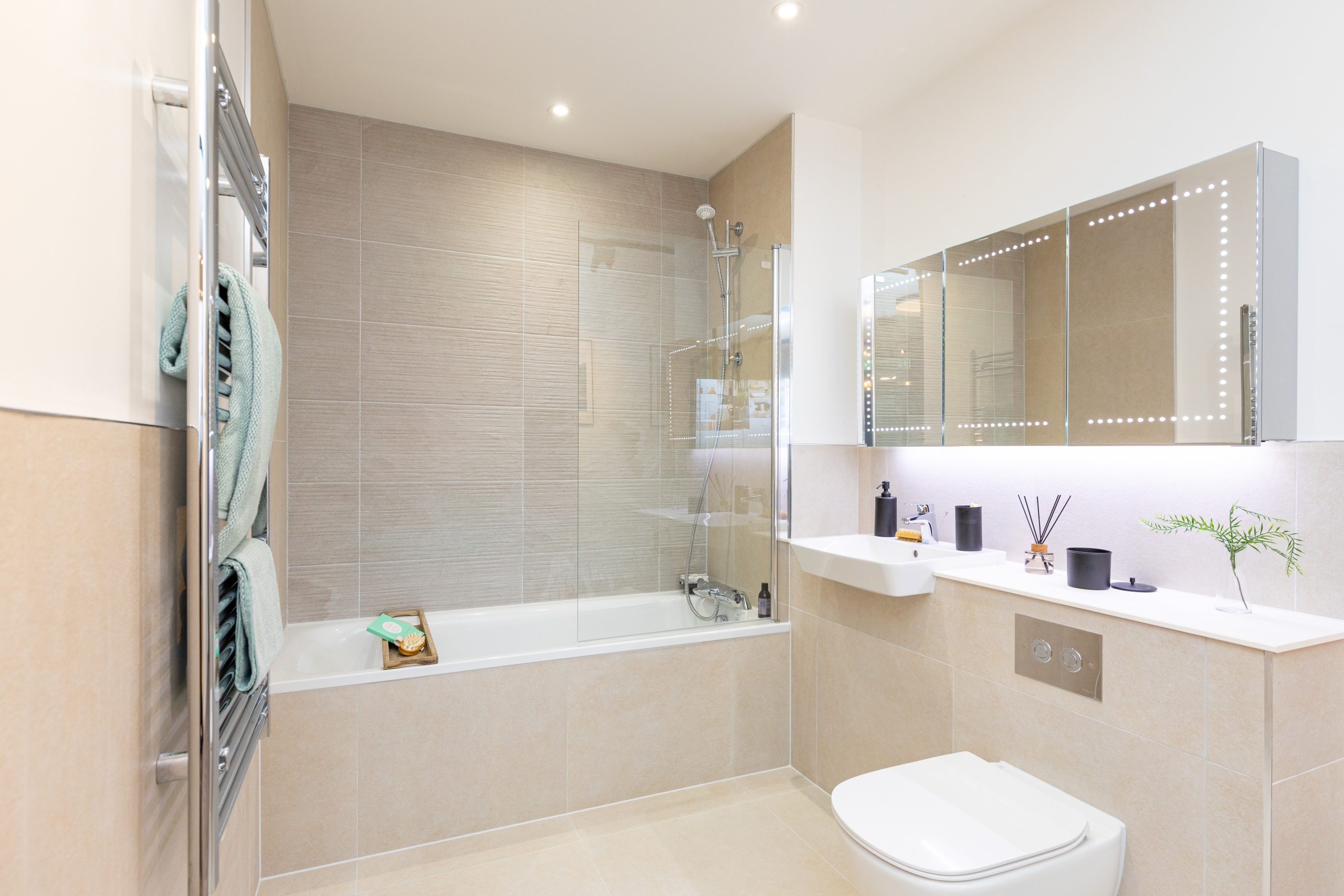 bright modern bathroom with a bathtub and a large mirror cabinet