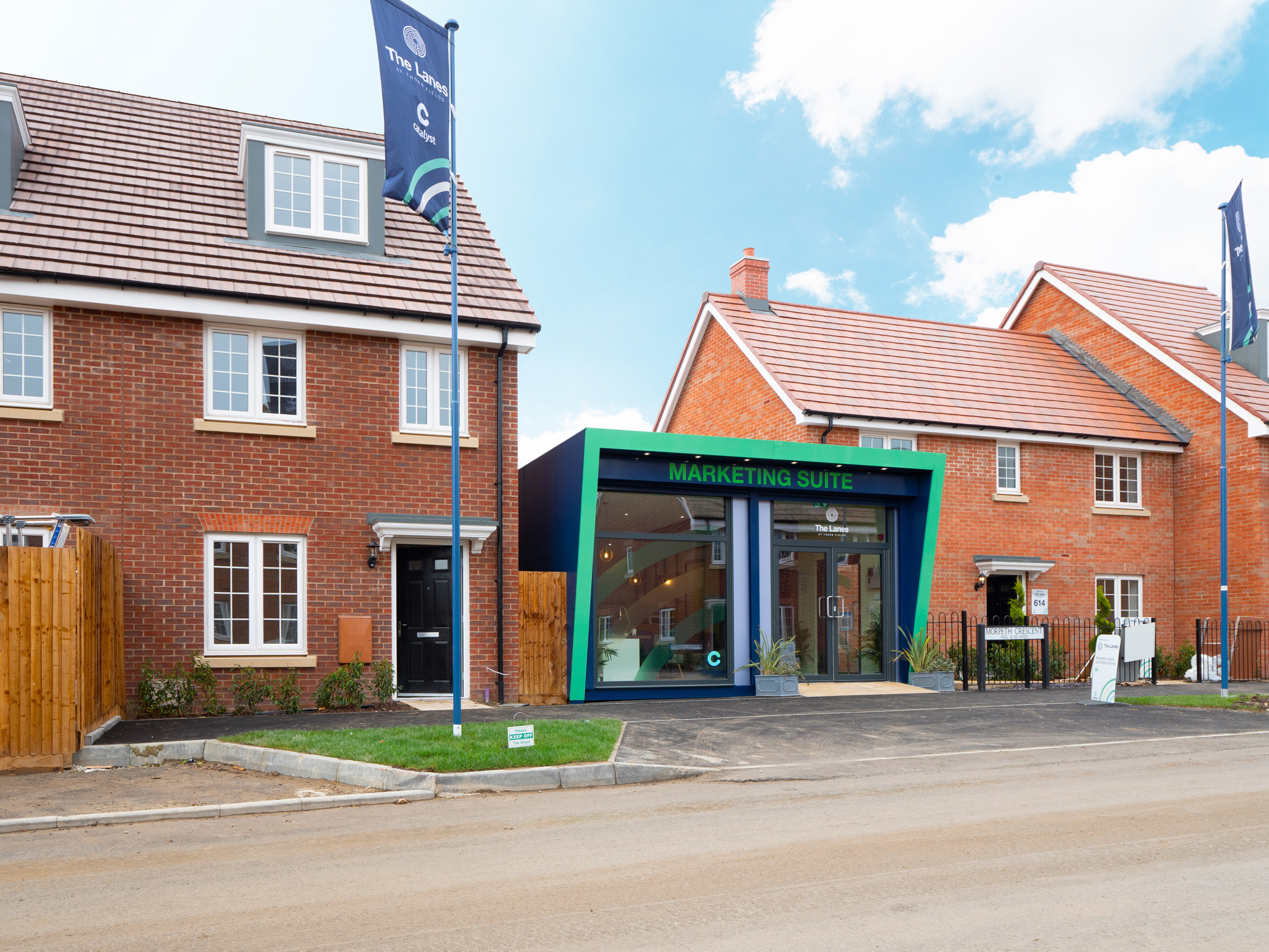 green and black marketing suite in between two modern houses