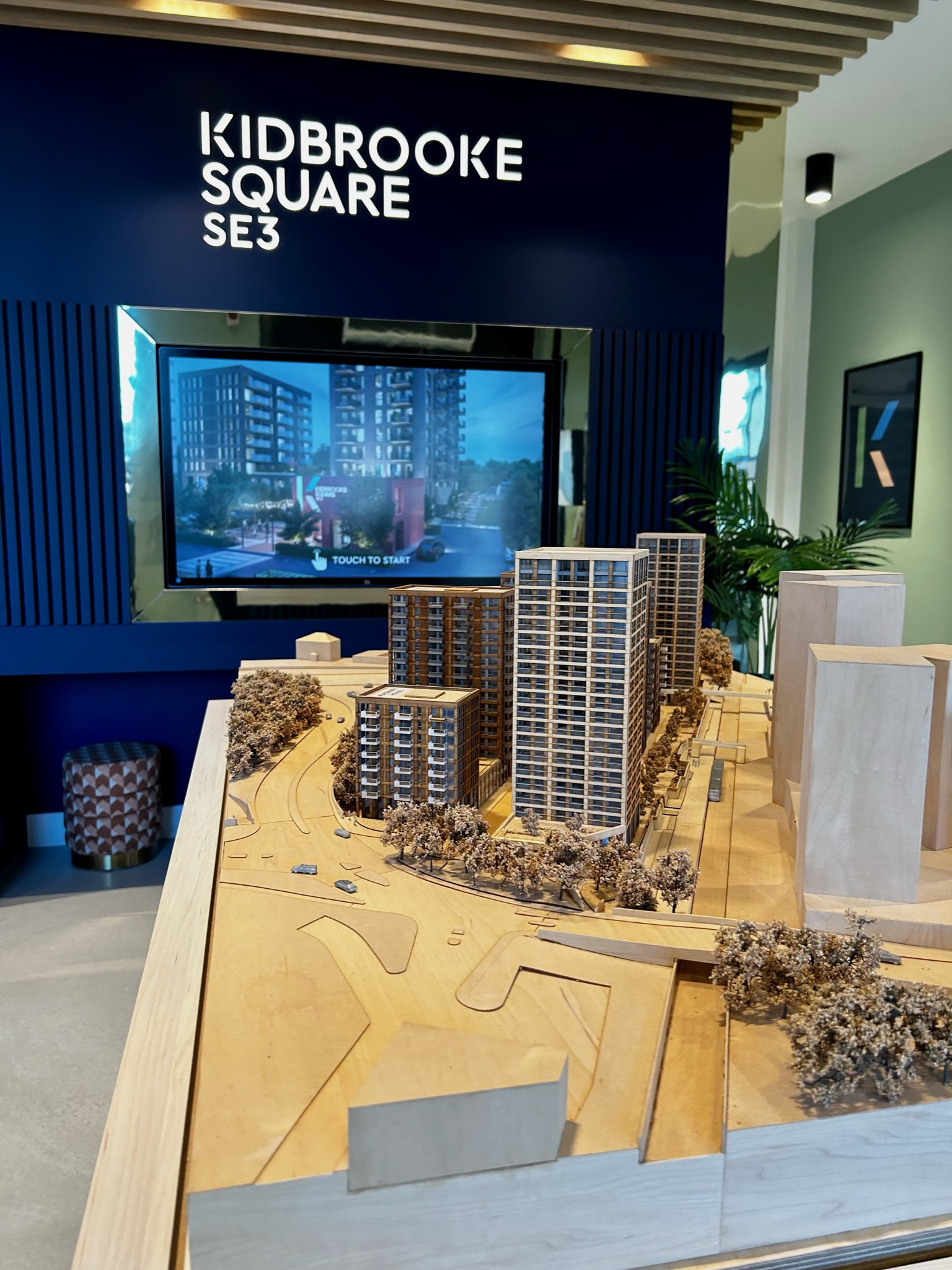 marketing suite with a large 3D model of the city around the development and a TV that showcases the development