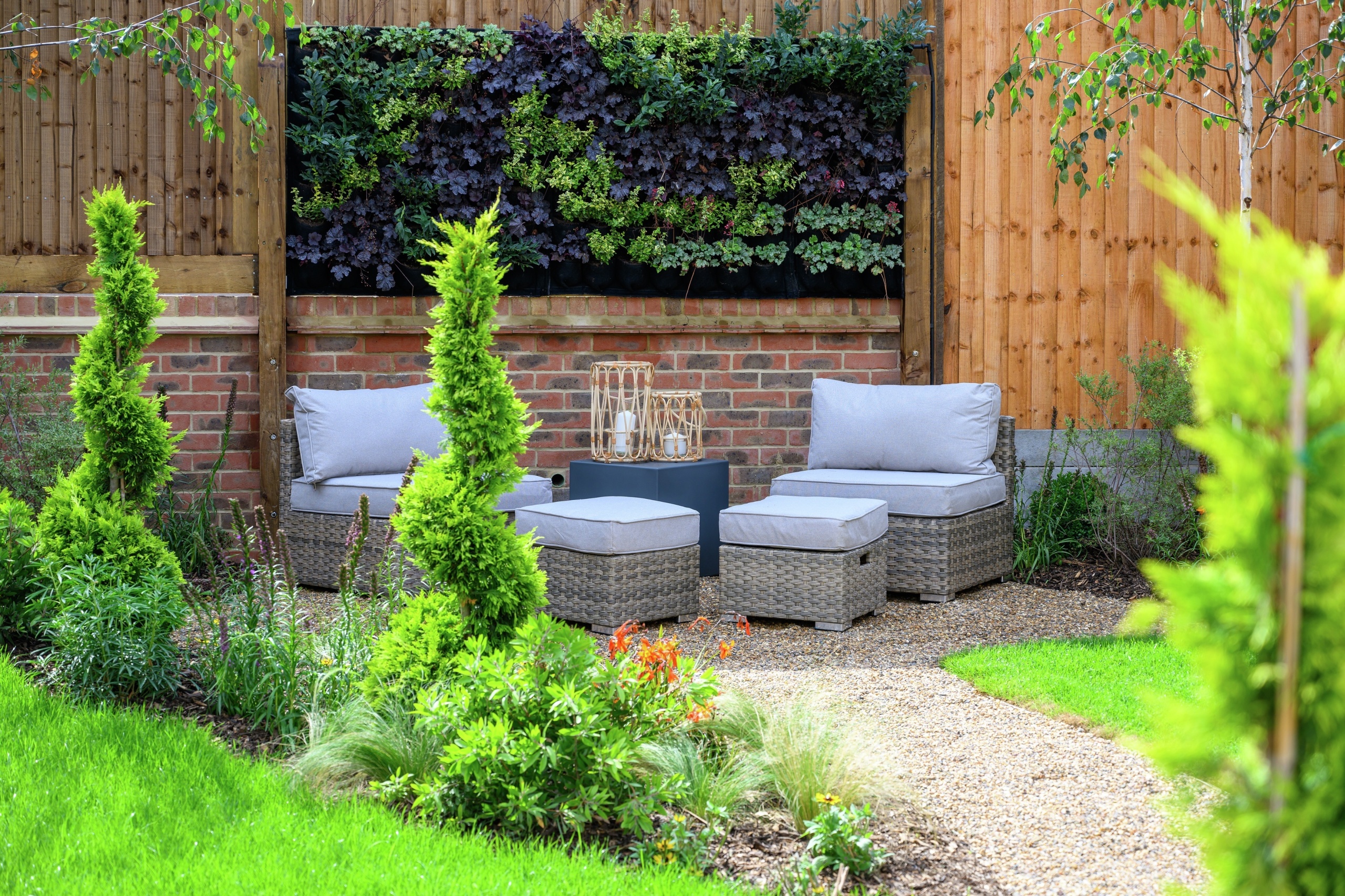 A outdoor space with two chairs and lots of green plants and bushes